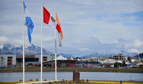 Flag on pole by mountain against sky