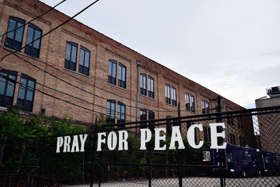 Low angle view of text on building against sky