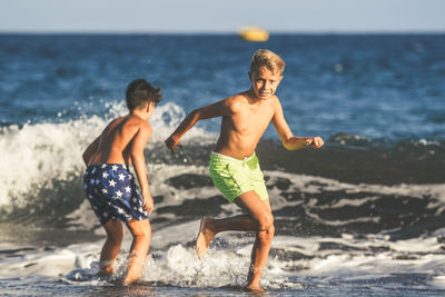 Rear view of father and son on beach