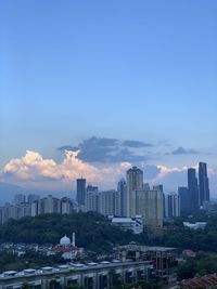 Buildings in city against sky during sunset