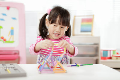 Young girl playing creative 3d shape toy for homeschooling