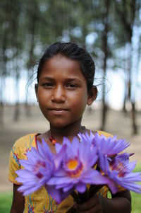 Close-up portrait of woman holding flower