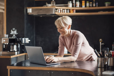 Woman using phone while sitting on table