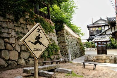 Signboard against stone wall