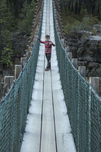 Woman standing on footbridge