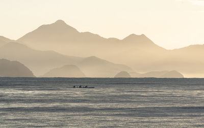 Scenic view of sea and mountains against sky