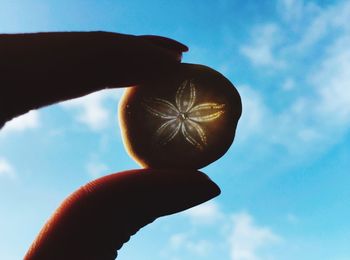 Low angle view of cropped hand against clear sky