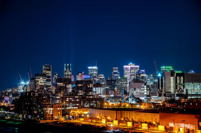 Illuminated buildings in city against sky at night