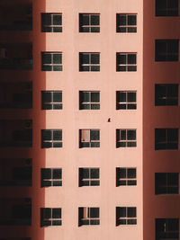 Full frame shot of building showing symmetrical pattern of windows and balconies 