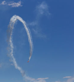 Low angle view of airplane flying against blue sky