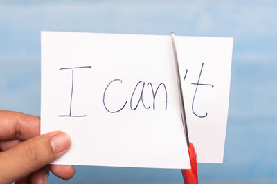 Close-up of hand holding text on paper