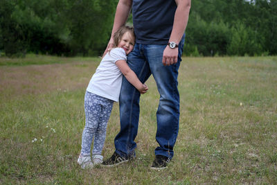 Low section of mother and daughter on grass