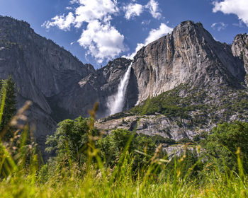 Low angle view of waterfall and mountains