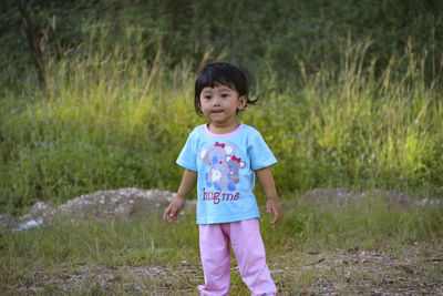 Portrait of cute girl standing on field