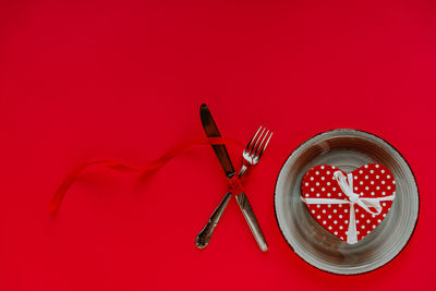 High angle view of fire on table against red background