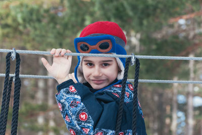 Close-up portrait of cute smiling boy holding ropes