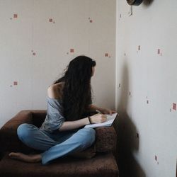 Rear view of woman sitting on bench