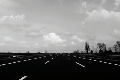 Empty road against cloudy sky