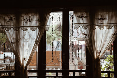 Beige handmade crochet cotton fabric curtain near glass window