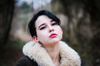 Portrait of woman wearing pink lipstick in forest