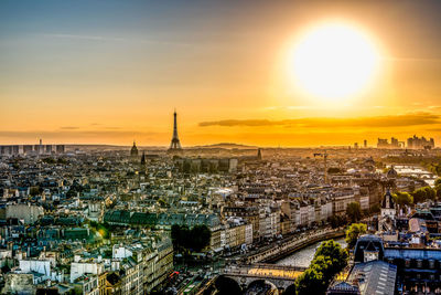 Distant view of eiffel tower amidst cityscape during sunset