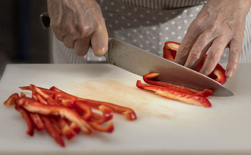 Cropped image of person preparing food on cutting board