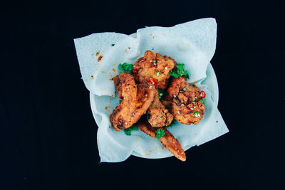 High angle view of fried food in bowl on black background