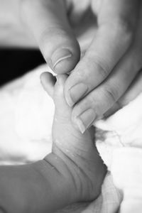 Cropped hand of mother holding baby foot