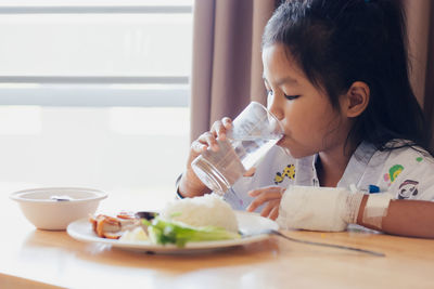 Young woman drinking juice at home