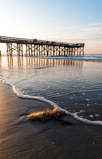 Pier over sea against sky during sunset