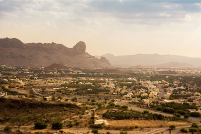 Aerial view of city and mountains against sky