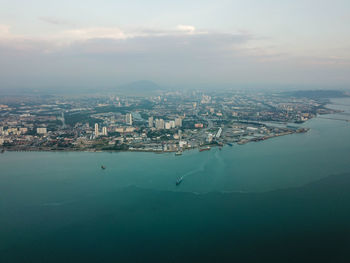 High angle view of townscape by sea against sky