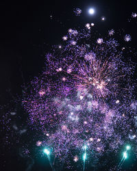 Low angle view of firework display at night