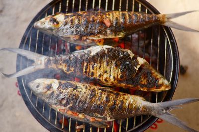 High angle view of fish cooking on barbecue grill