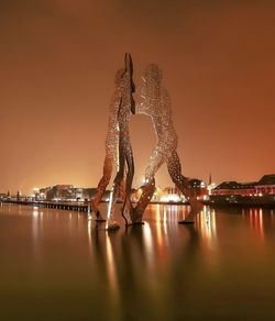 Scenic view of illuminated lake against sky at night