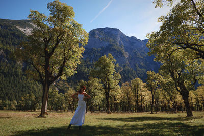 Woman standing by tree on field