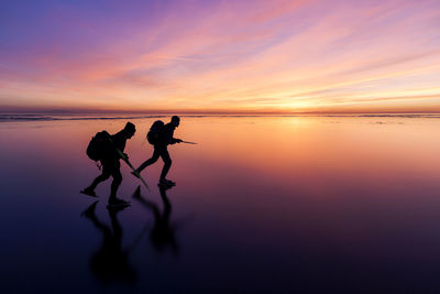 People long-distance skating at sunset, vanern, sweden