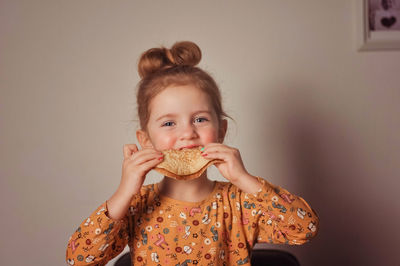 Portrait of young woman eating food at home