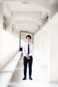Full length portrait of young man standing in building