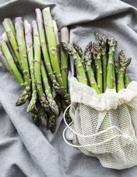 Fresh green asparagus on grey textile background. flat lay