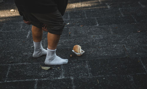 Low section of woman standing on sidewalk