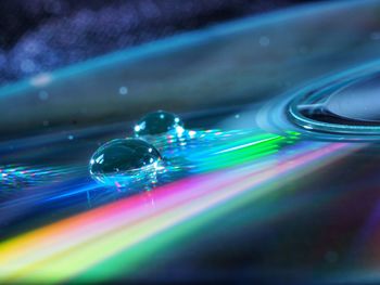 Close-up of water drops on multi colored light