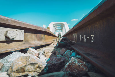 Close-up of rusty sign against blue sky