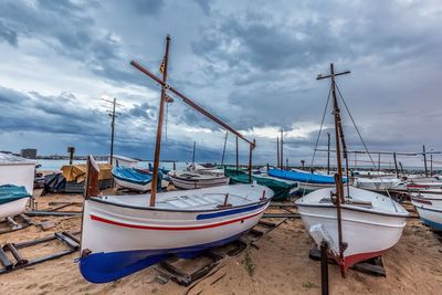 Boats moored on beach against sky