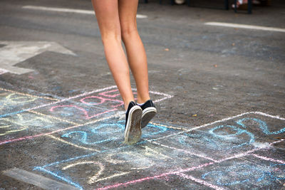 Low section of teenage girl playing outdoors