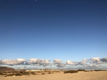 Scenic view of desert against clear blue sky