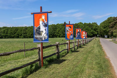 Information sign by fence against sky