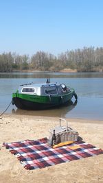 Boats moored on shore against clear sky