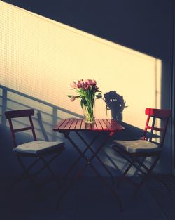 Vase on table by chairs