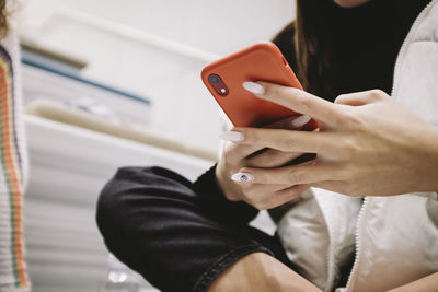 Midsection of woman using mobile phone